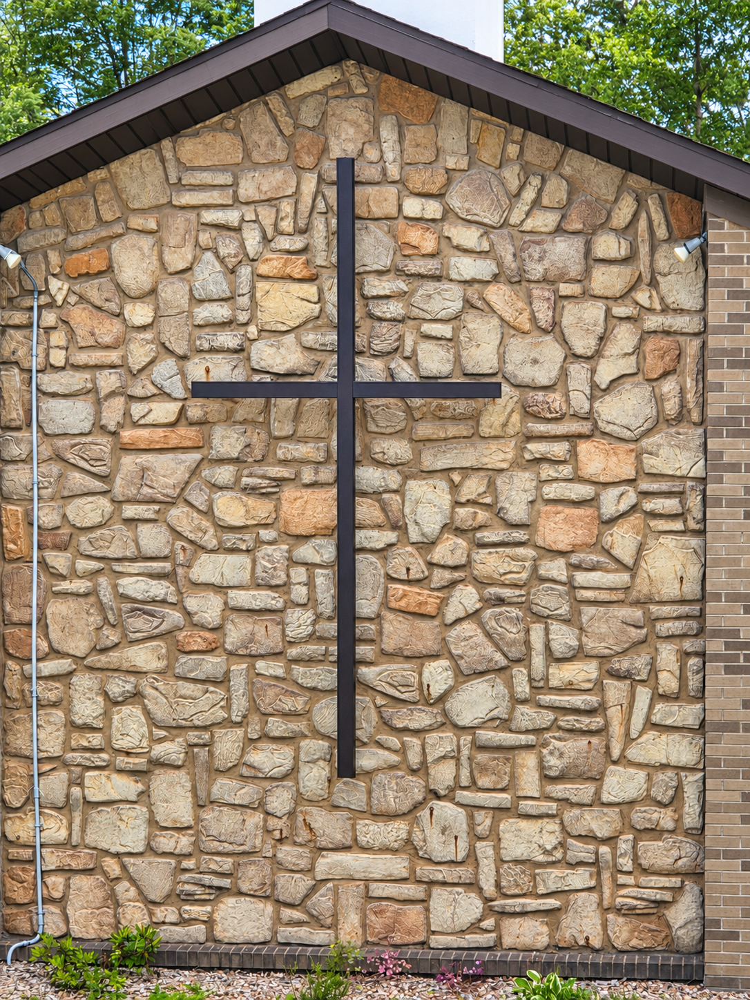 Cross mounted on the stone facade of Grace Bible Church